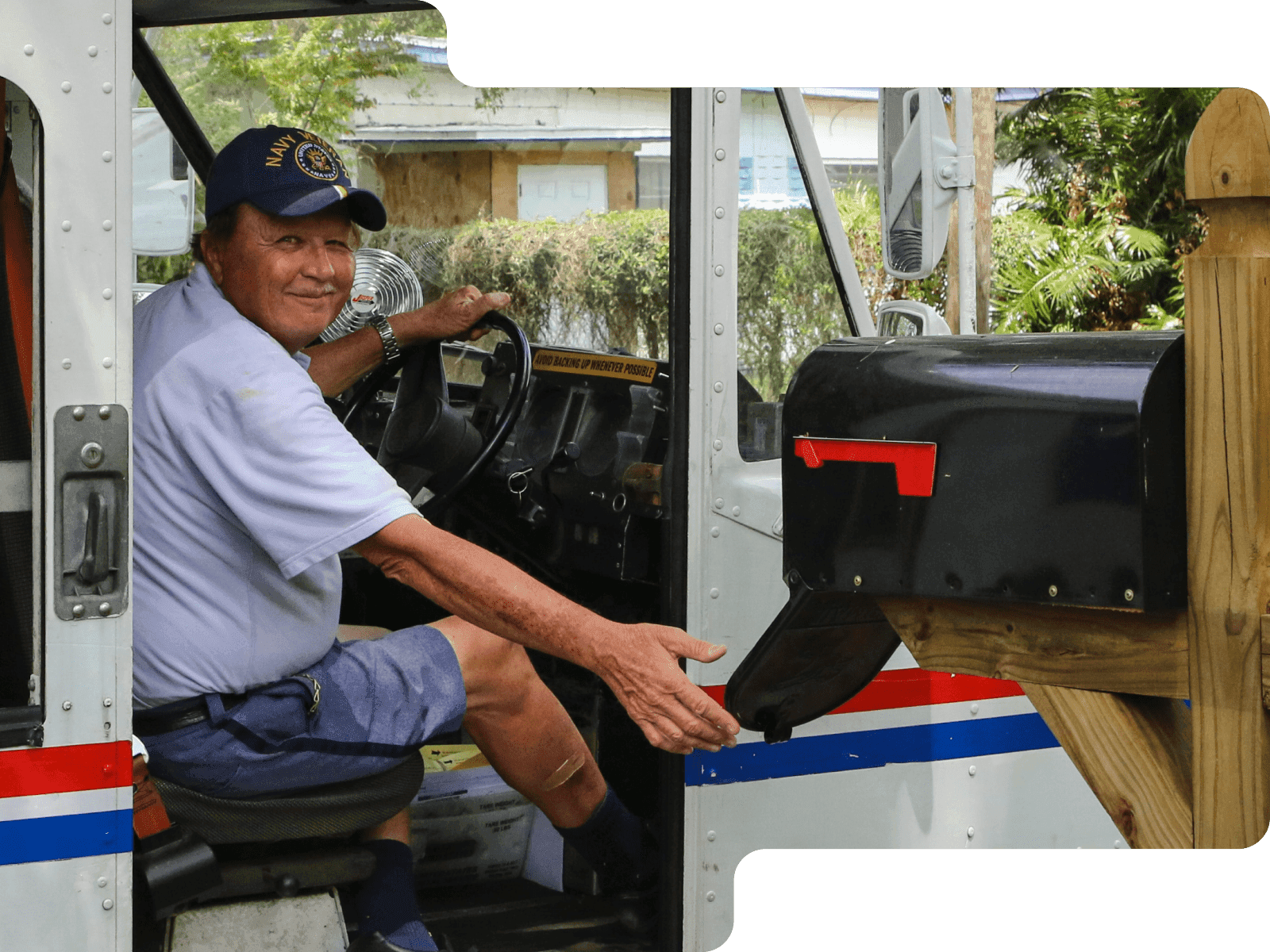 Driver looking out the door of a truck delivering mail